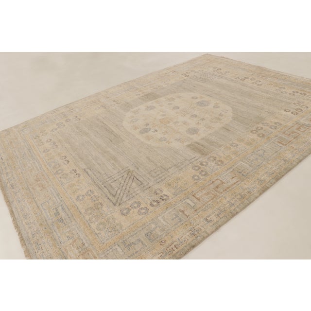 This 9x12 contemporary Khotan rug in natural silk reinterprets classic design with a softly faded medallion, floral...