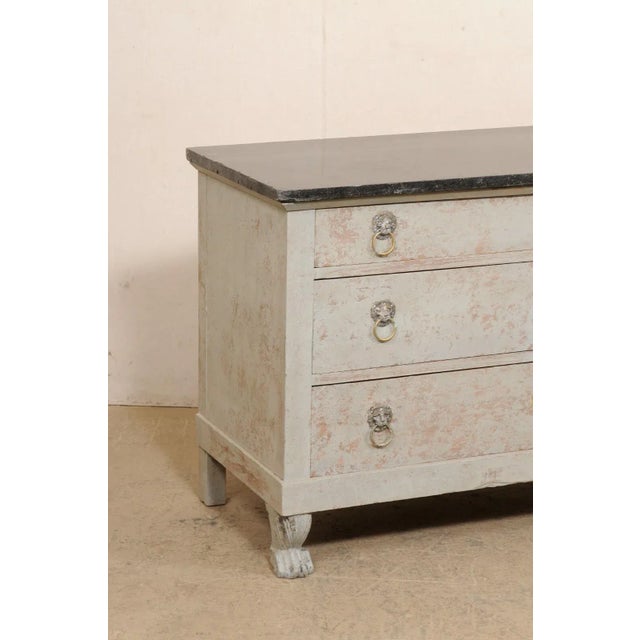 A French Neoclassical commode with four drawers and marble top from the 19th century. This antique chest from France...