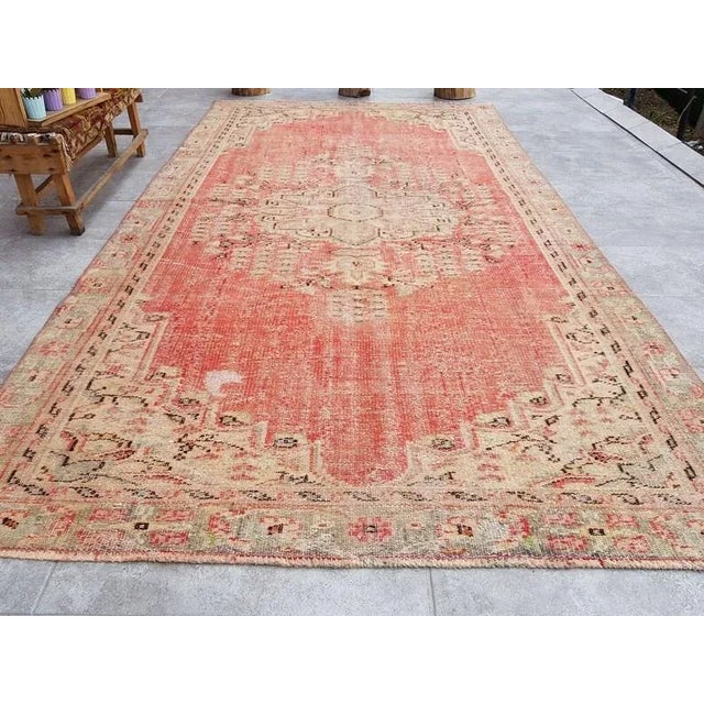 This is a vintage Turkish Oushak rug from the 1960s. The piece was hand-knotted.