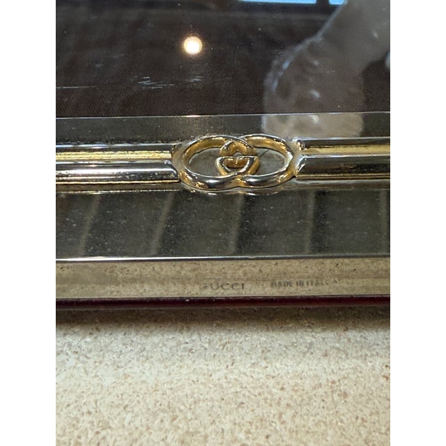 Elegant vintage Gucci photo frame crafted in a polished silver-tone metal with gold-tone bamboo-inspired trim accents. The...