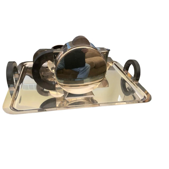 Silver-plated metal and ebony wood construction. Four piece: tray, teapot, sugar bowl, creamer. Christian Fjerdingstadt...