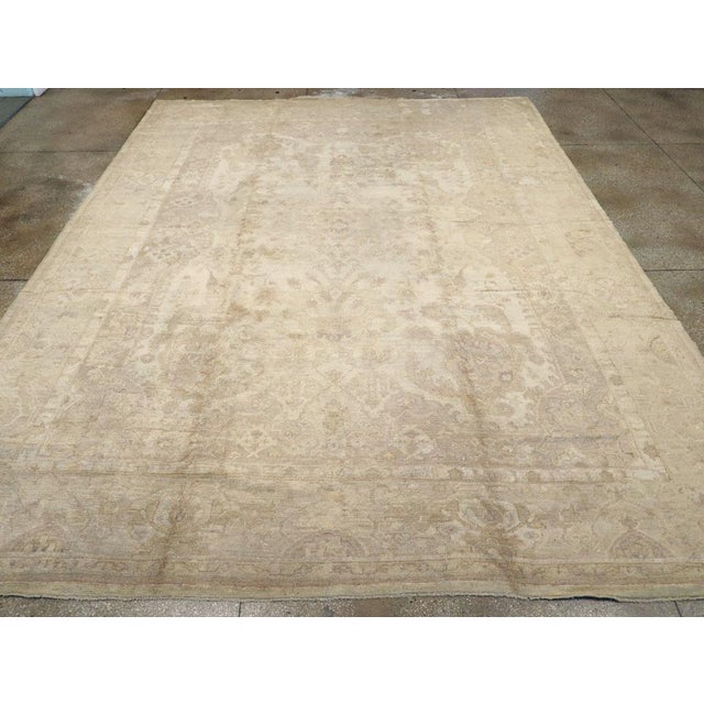 An antique Turkish Oushak large room size carpet. This west Anatolian workshop carpet is a study in ivory and beige tones....