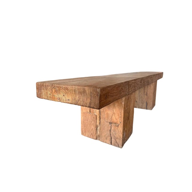 A sculptural bench crafted from solid teak wood, distinguished by its strong architectural presence and grounded,...