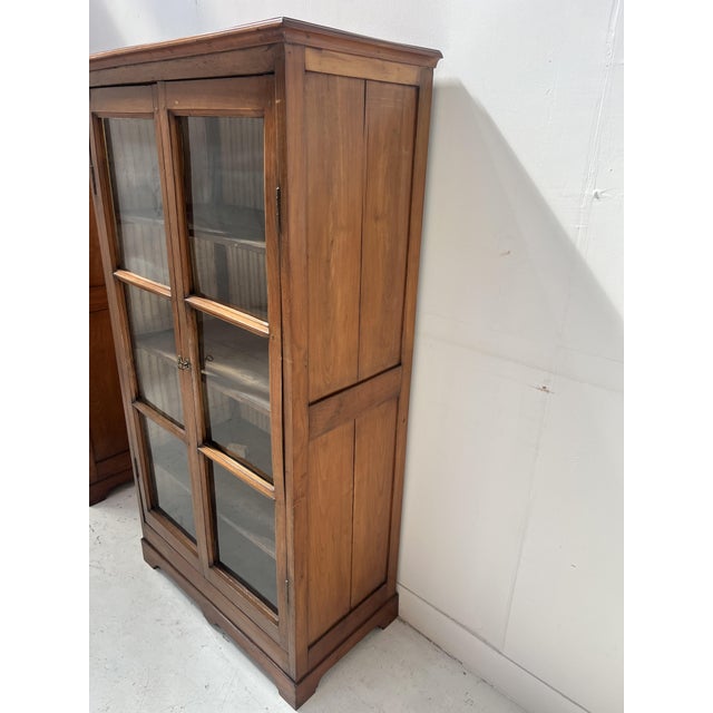 Pair of elegant display cabinets in solid cherry wood. They open with two doors, each with six clear glass panes. Three...