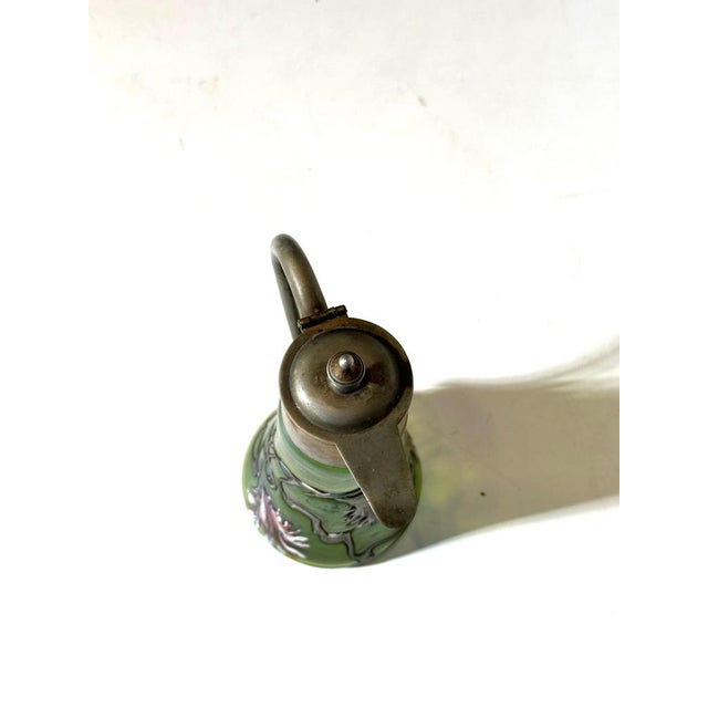 Elegant Art Nouveau claret jug attributed to Lötz, featuring an iridescent green glass body with applied flowing organic...