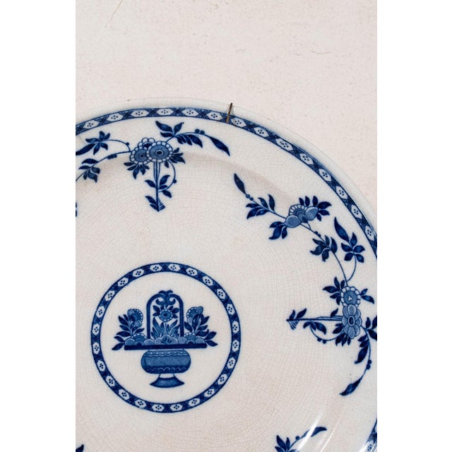 Antique Minton Delft round serving platter featuring a classic blue and white transferware design with a scalloped rim....