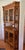 This large vintage corner cabinet showcases beautifully designed oak features and beveled glass panes and mirrors...