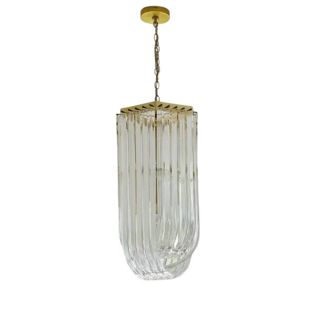 Long mid-century Lucite ribbon chandelier with brass finish.