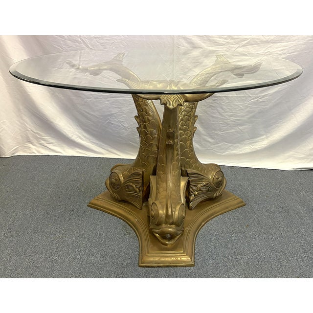 Stunning Italian brass dining table from the 1960's. It features three koi fish made of heavy brass with uplifted tails to...