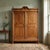 Umbertino walnut wardrobe. Front with bipartite and paneled doors, matching the sides, cymatium with central leaf carving...