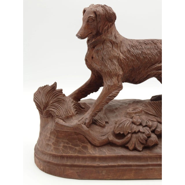 Large early 20th-Century Swiss Black Forest hand carved spaniel sporting or hunting setter dog. The dog is poised on a...