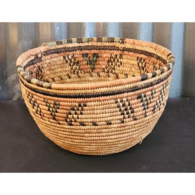 A beautifully handcrafted vintage coiled basket featuring intricate natural-fiber weaving and striking geometric...