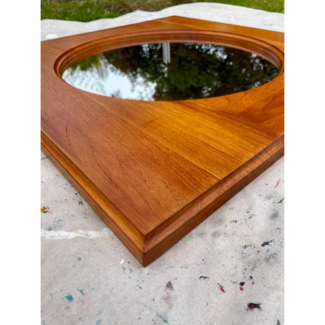 Danish modern teak round wall mirror produced by Hadsten Træindustri, Denmark, circa 1970s–1980s. This piece features a...