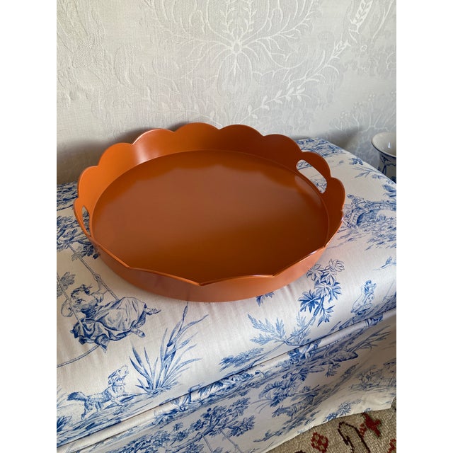 Hand painted lacquer scalloped tray in soft pumpkin orange. 15” x 2” Tray is sturdy bamboo and adds a fashionable pop of...