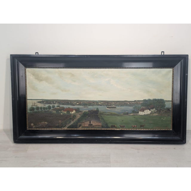 Oil on canvas in a wooden frame This oil on canvas painting in a wooden frame depicts a city view. The frame is dark, and...