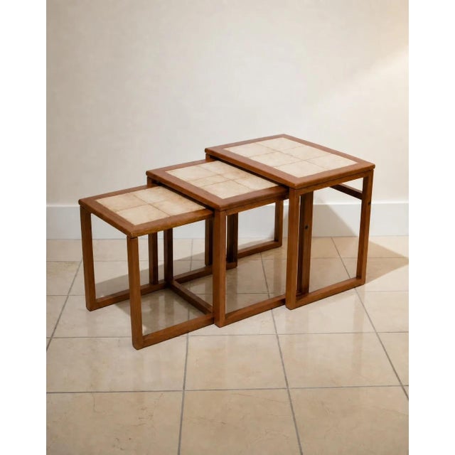A beautiful set of three 1970s Scandinavian nesting tables featuring solid teak frames and tiled tops. Each table nests...
