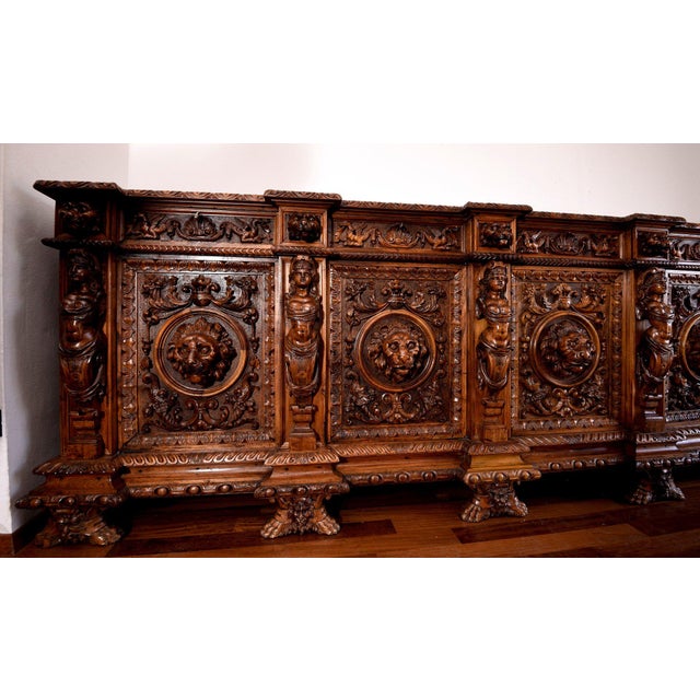 Solid walnut sideboard, completely carved and engraved with bas-reliefs and grotesque figures, making this piece of...