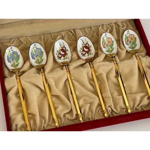 Set of six Japanese silver cloisonné demitasse spoons by Royal Seven, circa 1960s. Each spoon features a white ground with...