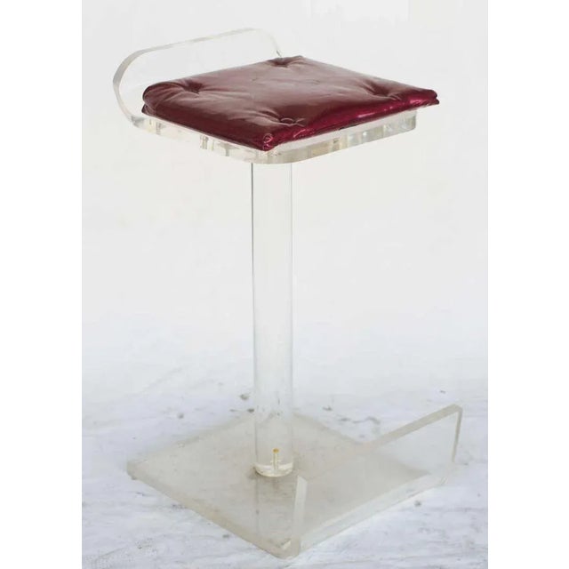 Lucite bar stools in the style of great artists, each featuring a footrest and magenta star dust vinyl seat pad. Elevate...