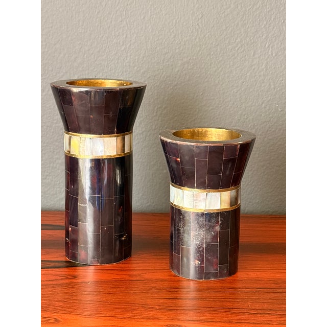 Pair of tessellated horn and mother of pearl candleholders with brass inserts in the manner of Maitland Smith. Larger is...