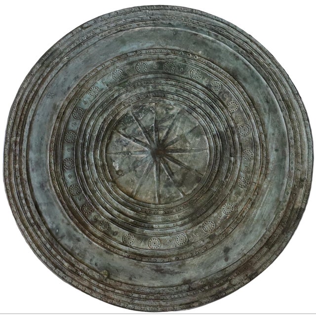 Southeast Asian hollow bronze rain drum with verdigris patina, engraved handles, and intricate geometric patterns. The top...