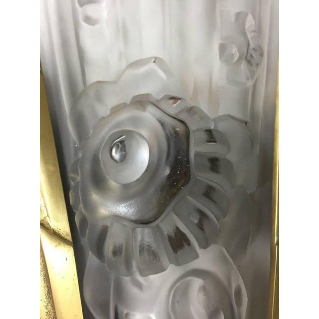 A pair of French Art Deco wall sconces by French artist Genet et Michon in clear frosted glass shades with floral motif...