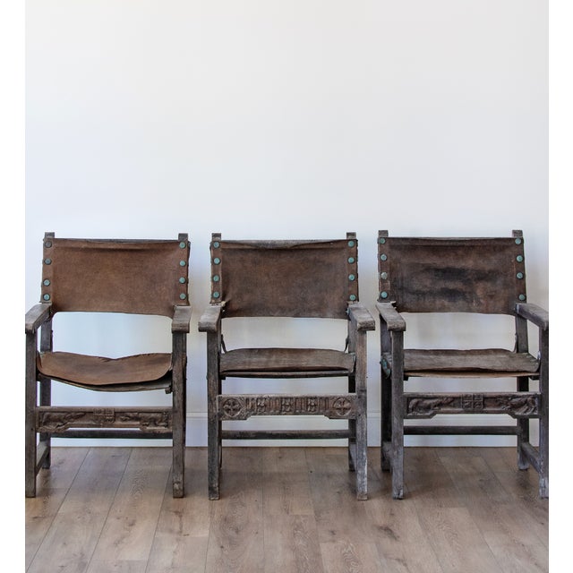An beautifully rustic set of seven Spanish Colonial armchairs dating to the 18th century, crafted from richly patinated...