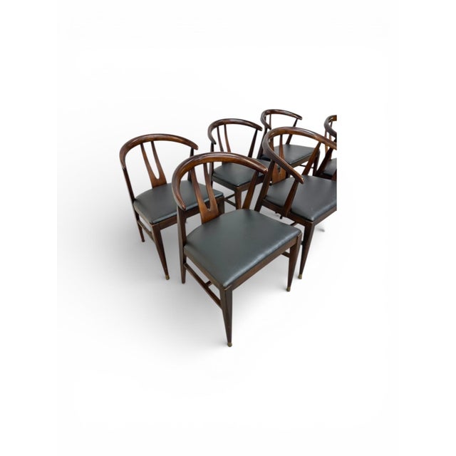 This striking set of six Mid-Century Modern wishbone style dining chairs is a perfect blend of sculptural elegance and...