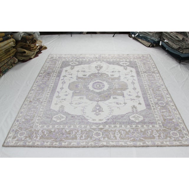 Hand woven Indian rug featuring a Persian Heriz design on a beige colored field and taupe border. Hand-woven with a wool...