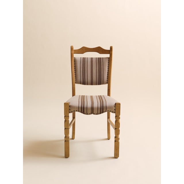 A beautifully crafted set of six Danish dining chairs featuring sculpted oak frames and gently curved ladder backs. The...