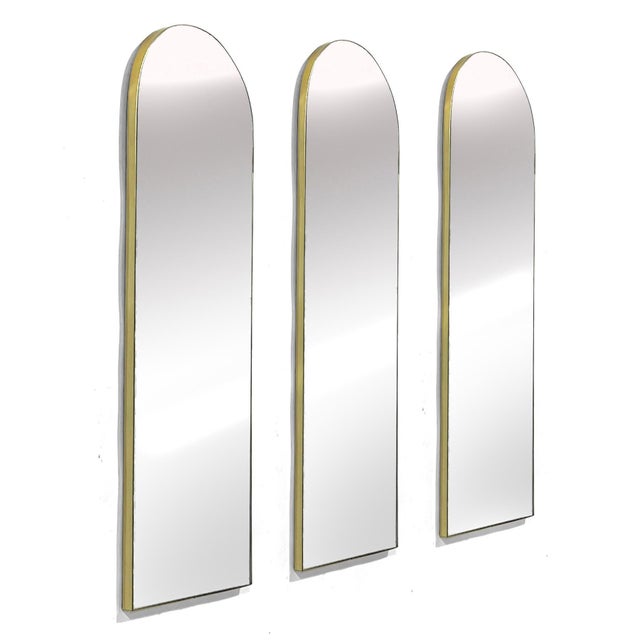 These three wall mirrors by Regent Glass Co. with arched tops and slender brass colored frames lend the perfect touch of...