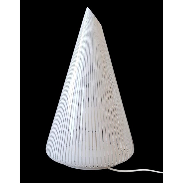This table lamp embodies the timeless elegance of 1970s Italian design. Featuring a sleek, conical silhouette with a...