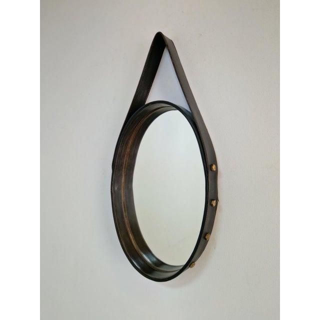 Florentine oval leather mirror, brass, Jacques Adnet, Italy, 1960s Florentine oval mirror framed with Black leather and...