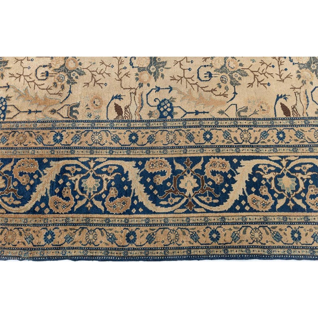 A turn of the century product, this antique Persian Tabriz rug features an elaborate design of botanical abstractions and...