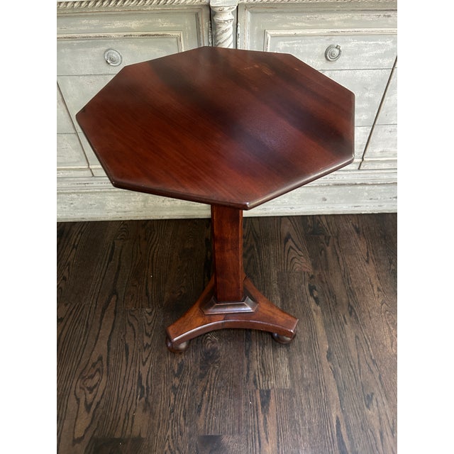 Elegant early 20th century Edwardian style mahogany wine table featuring a shaped octagonal top raised on a clean pedestal...