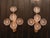 Pair of vintage gold-plated brass wall sconces with five arms topped with frosted glass flowers. Each sconce features a...