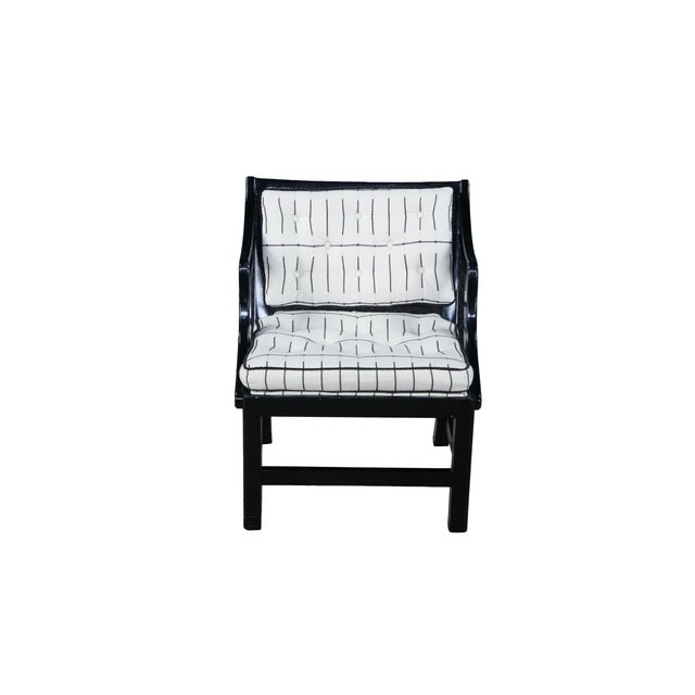 This Hollywood Regency or Chinoiserie-style arm chair features a striking, high-gloss black lacquered wood frame that...
