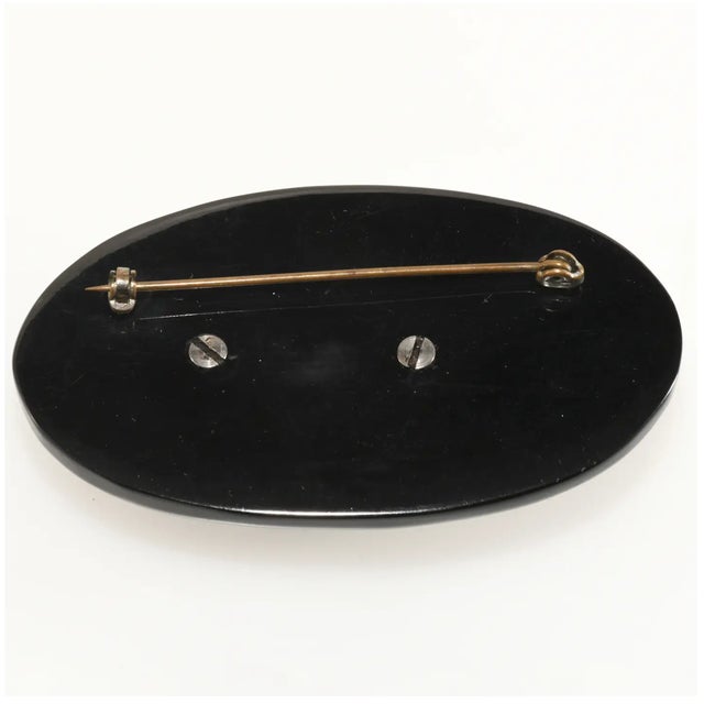 Heavily carved brooch made of black Bakelite with beautifully rendered acorn motif depicting one full and one empty cup....