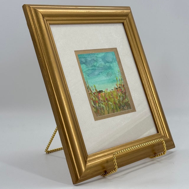 Original contemporary watercolor painting depicting a vibrant wildflower meadow beneath a dramatic turquoise sky....