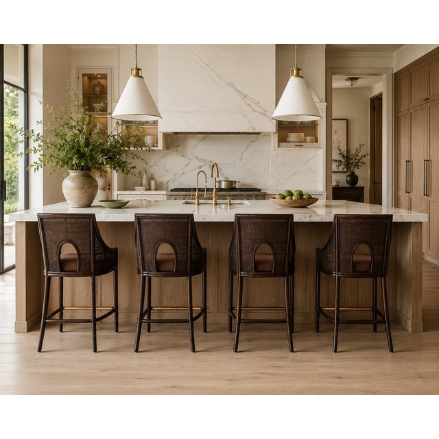 An elegant set of four authentic Barbara Barry for McGuire bar stools featuring woven caned backs, sculptural curved arms,...
