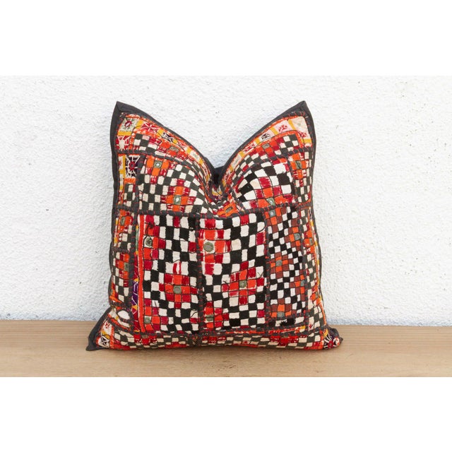 This 16-inch square pillow is a breathtaking fragment of Rajasthani heritage, repurposed from antique Banjara textiles...