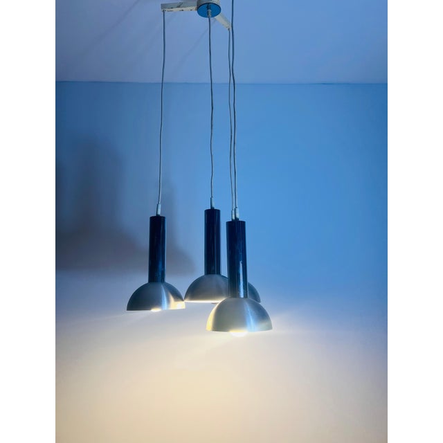Stunning Space Age cascading ceiling lamp from the 1970s, featuring four metal shades in a sleek, futuristic design. This...