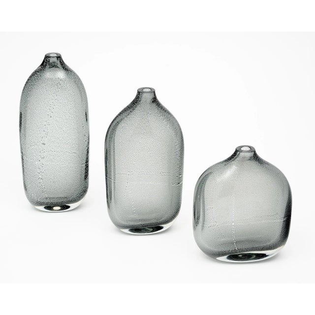 Set of three vases or bottles of hand-blown Murano glass. Each piece is crafted using the avventurina technique where...