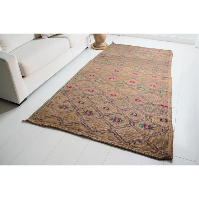 This is a vintage Turkish Oushak rug from the Mid 20th Century. The piece was hand-knotted.