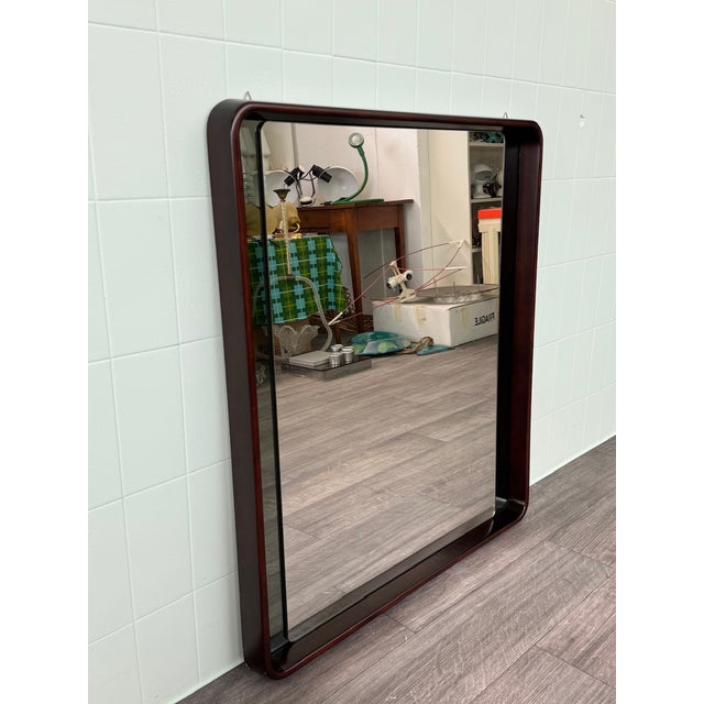 Rectangular mirror made in Italy in the 1970s. Walnut-stained wooden frame. It has two smoked glass side panels.