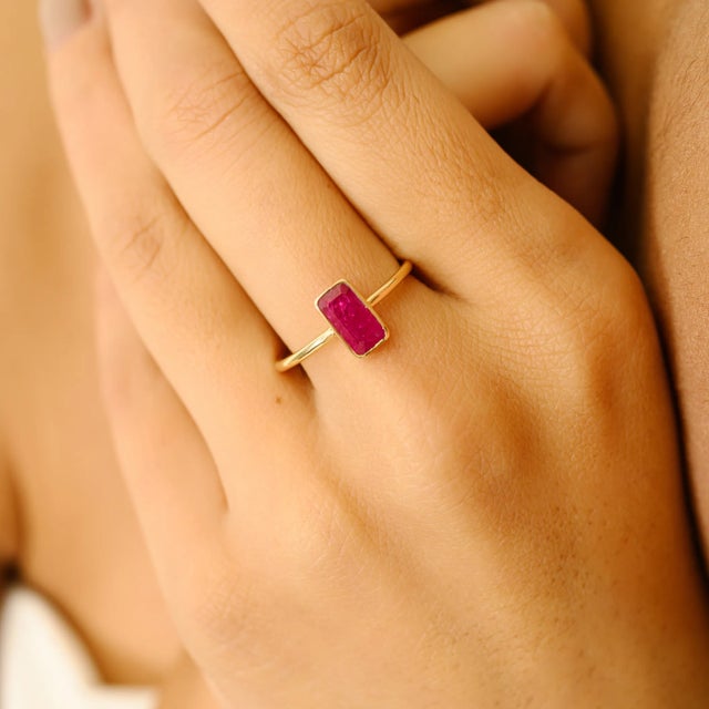 Add a bold yet refined touch to your jewelry collection with this exquisite 18K gold ruby solitaire ring. Featuring a...