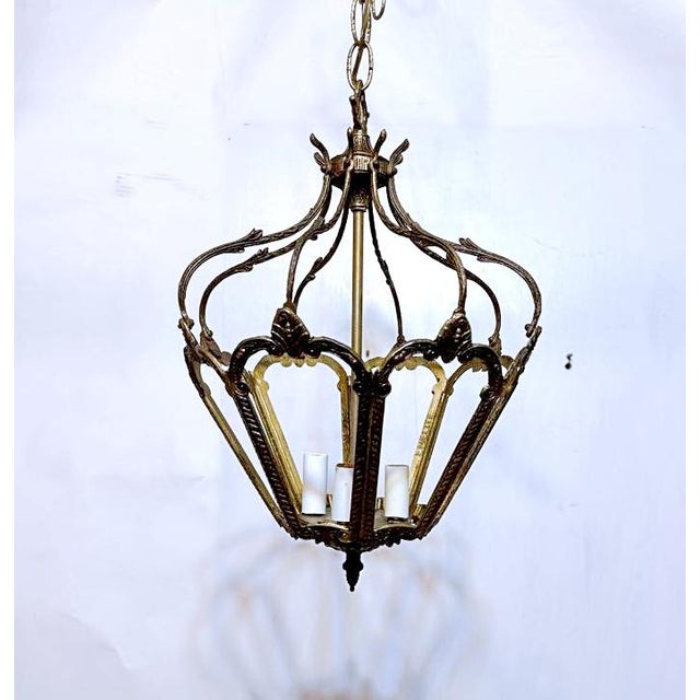 Antique gilded bronze hall lantern with four candelabra base lights surrounded by eight bronze open sectionals giving a...
