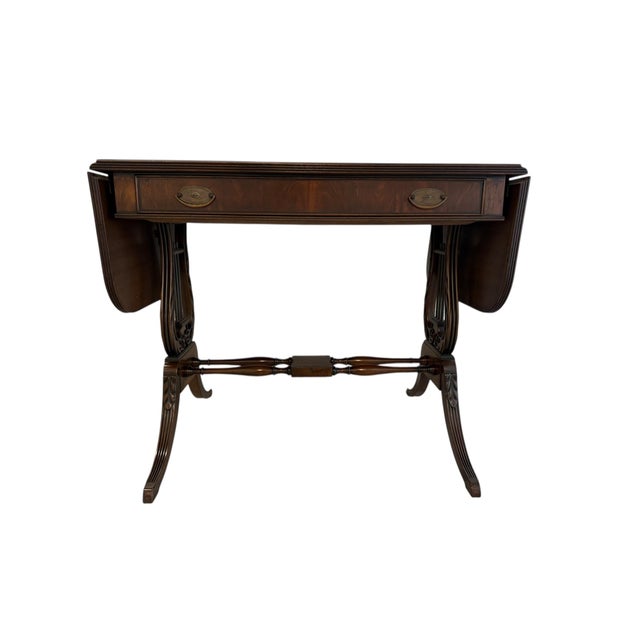 This mahogany drop-leaf table, dating to the early 1920s, reflects the craftsmanship of the Robert W. Irwin Furniture Co....