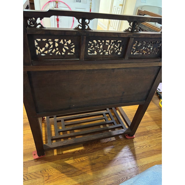 An exceptional Chinese hardwood desk or dressing vanity featuring an intricate, three-sided pierce-carved gallery top...