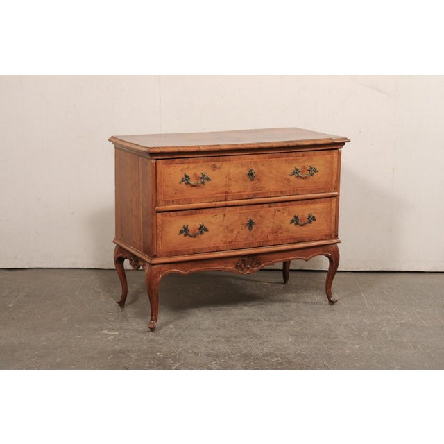 An Italian raised chest of two drawers, with veneer and inlays, from the turn of the 18th and 19th century. This antique...
